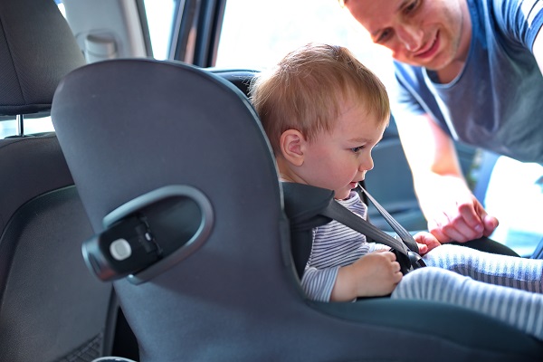 boy in the car seat and father 